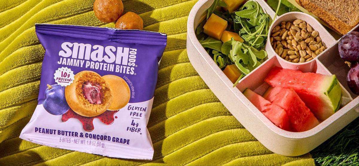 Smash PB Grape bites bag beside a bento lunchbox
